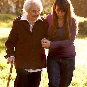 زن جوان در حال کمک کردن به پیرزن