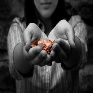 دختری در حال بخشیدن همه سکه های خود با دو دست